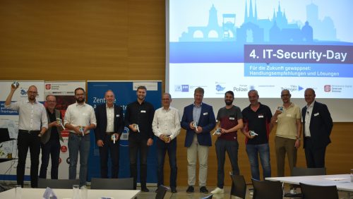 Referenten vor einer Leinwand auf der "4. IT-Security" steht