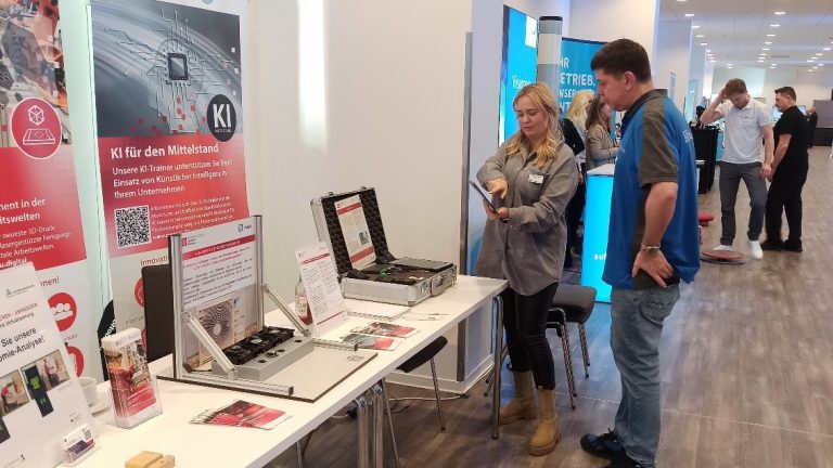 Zwei Personen vor einem Messestand