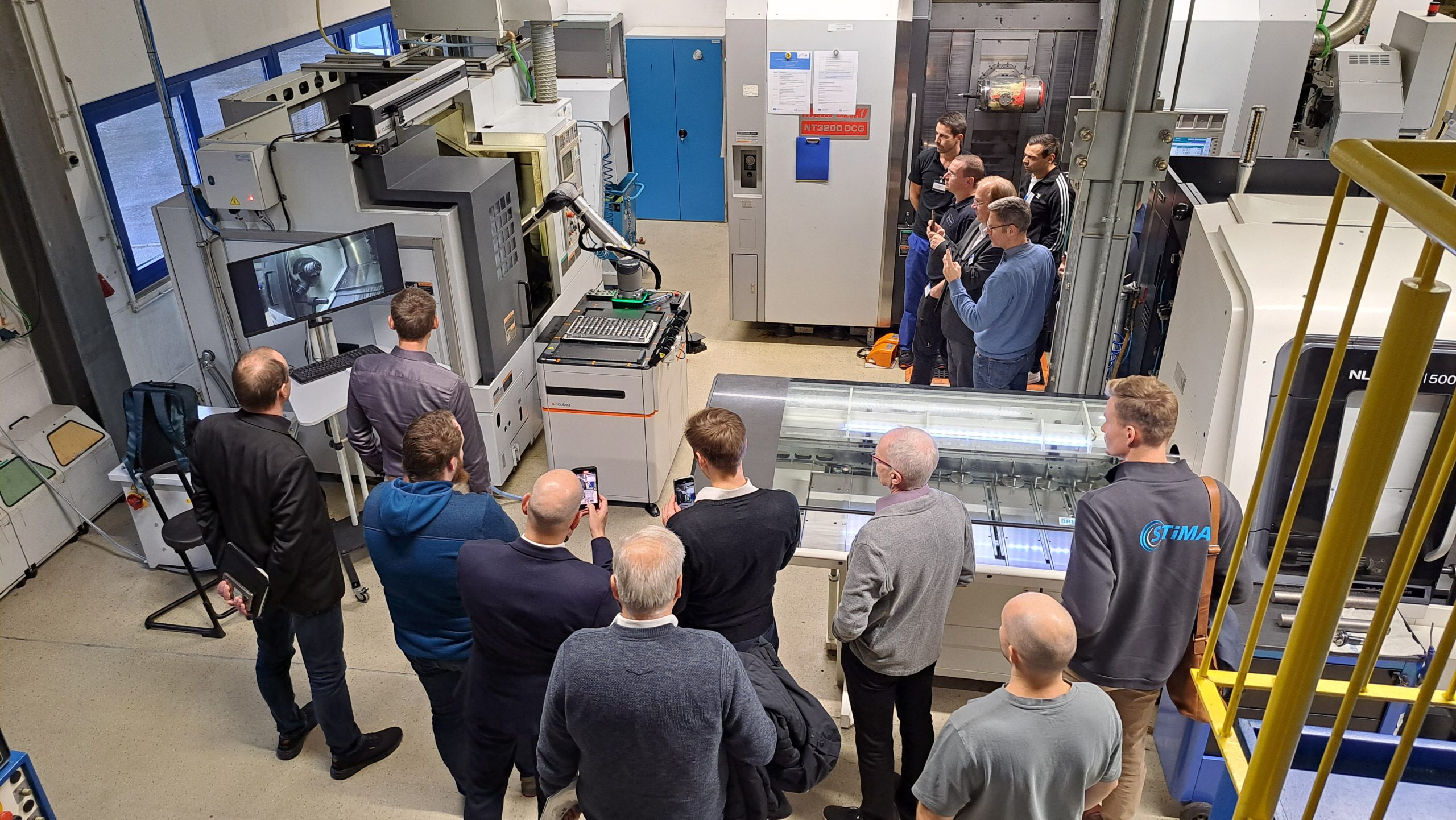 Gruppe Zuhörer steht in einem Labor und beobachtet das Versuchsfeld