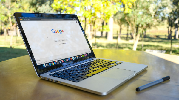 Keywords Google Suche Ein Laptop auf dem die Google such geöffnet ist seht auf einem Café Tisch