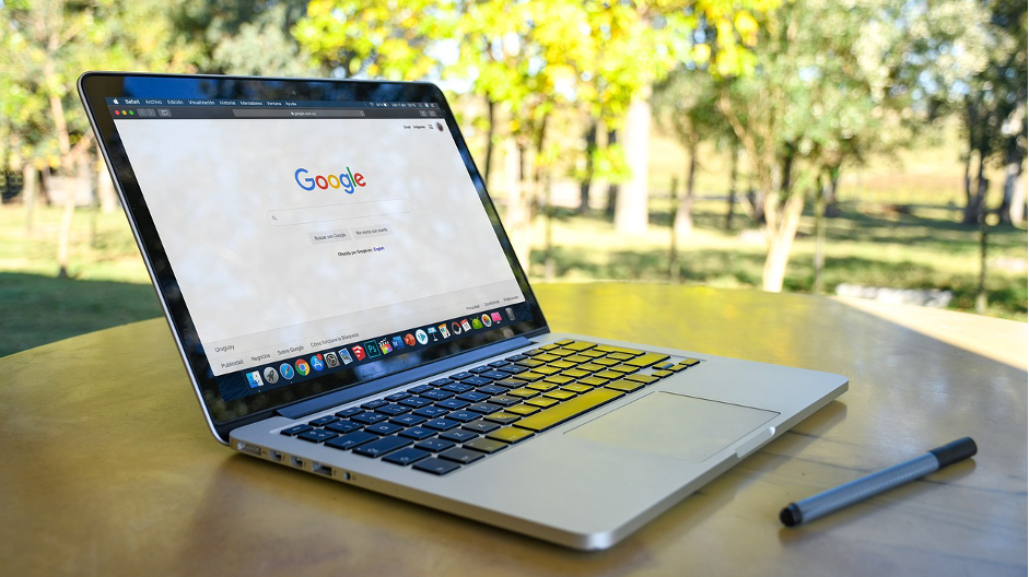 Ein Laptop auf dem die Google such geöffnet ist seht auf einem Café Tisch