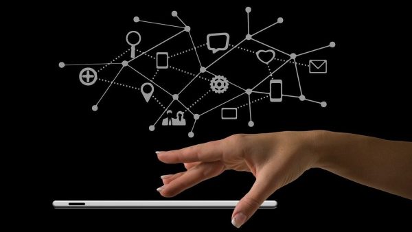 Digitalisierung und Innovationen Hand schwebt über einen Tablet und darüber sind verschiedene Icons zu sehen und miteinander verbunden