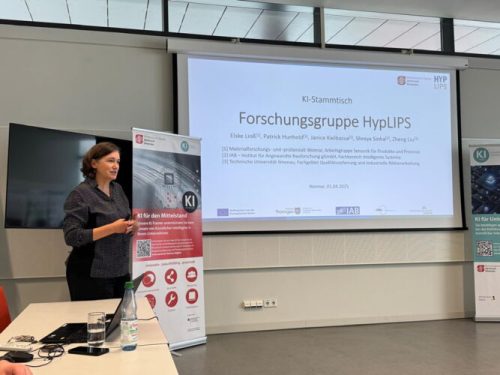 Eine Frau steht vor einer Präsentation und einem Roll-Up