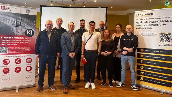 KI zum Frühstück Gruppe des Mittelstand-Digital Zentrums Ilmenau bei der Veranstaltung "KI zum Frühstück" gemeinsam vor Roll-Ups