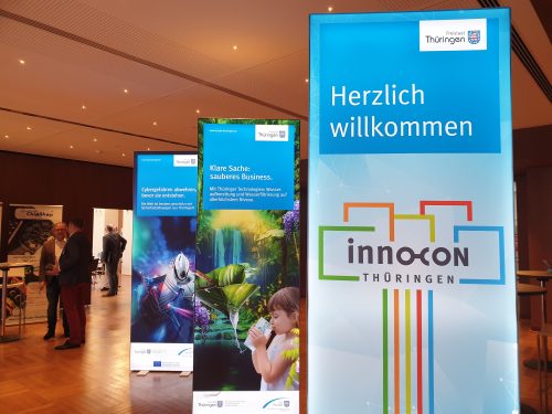 beleuchtete Banner im Eingangsbereich mit der Aufschrift "Herzlich Willkommen InnoCon"