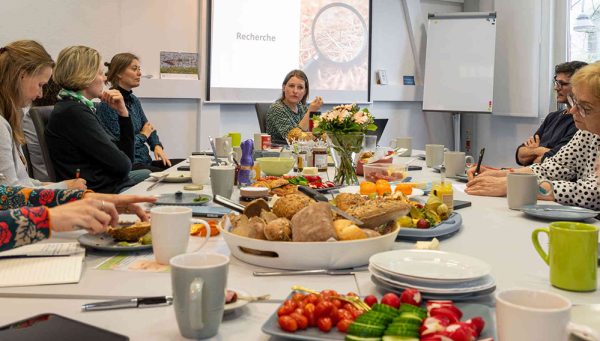 Dr. Kerstin Michalke (mittig) beim KI-Frühstück Personen sitzen an einem gedeckten Frühstückstisch