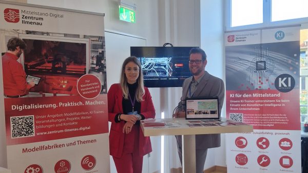 Vanessa Walter und Dr. Sebastian Gerth am Messestand der KEDi-Convention Zwei Personen vor einem Messestand