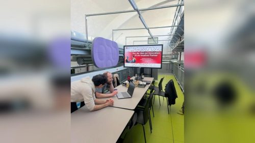 Zwei Menschen sitzen vor einem Laptop im StartUpLab in Jena