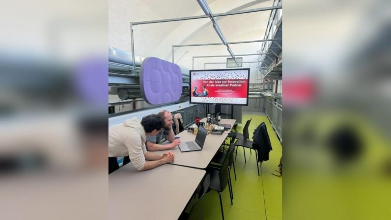 Zwei Menschen sitzen vor einem Laptop im StartUpLab in Jena