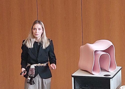 Eine Frau neben einem rosa Hocker