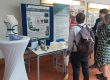 Menschen vor einem Messestand mit 3D-Druck-Exponaten