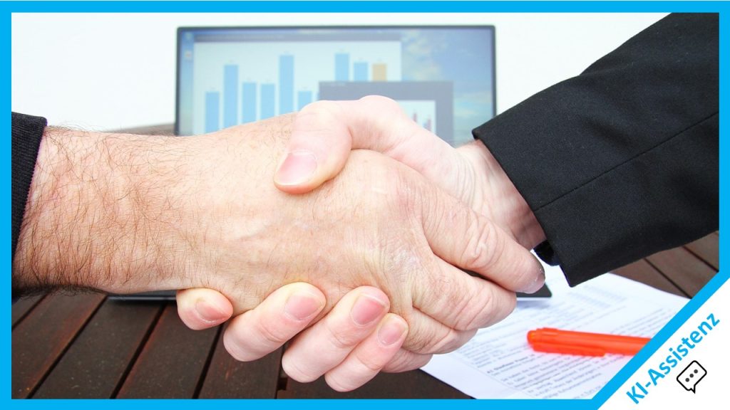 Zwei Hände die einen Handshake machen vor einem Laptop