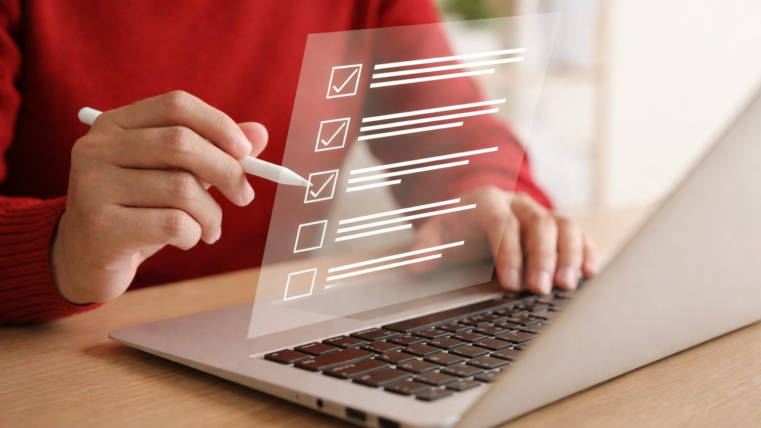 Digitale Umfrage am Laptop Person mit rotem Pullover sitzt an einem Laptop und markiert mit einem weißen Stift eine digitale Checkliste auf einer transparent dargestellten Benutzeroberfläche