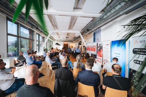 Zahlreiche Teilnehmende verfolgen einen Vortrag bei einer Fachveranstaltung zur smarten Fertigung in einem modernen Veranstaltungsraum.