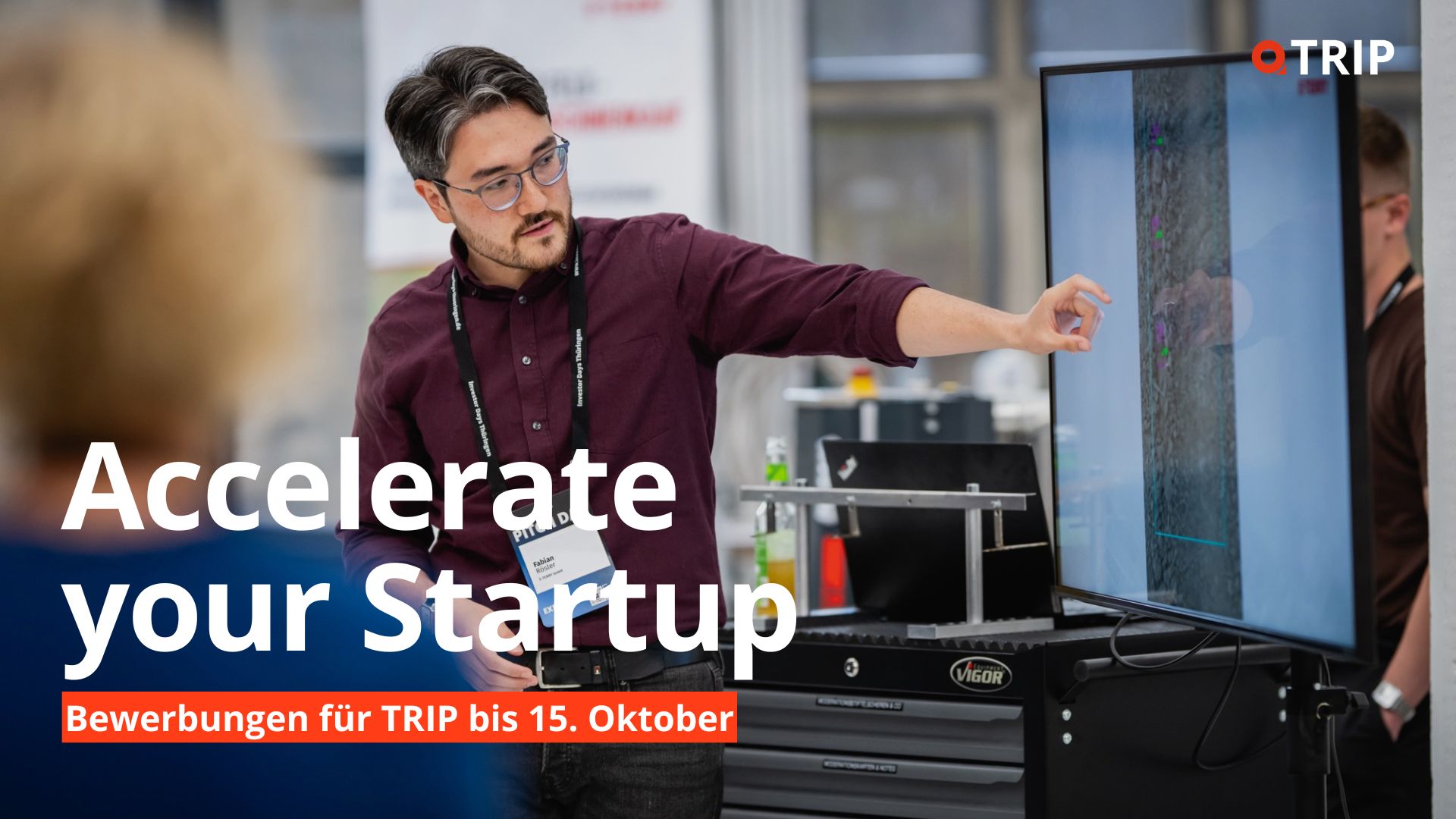 TRIP Startup-Bewerbungsaufruf Werbebanner für ein Startup-Programm: Eine Person präsentiert an einem großen Bildschirm technische Bilddaten in einer modernen Arbeitsumgebung. Im Vordergrund steht der Schriftzug „Accelerate your Startup“, darunter der Hinweis „Bewerbungen für TRIP bis 15. Oktober“. Oben rechts ist das TRIP-Logo zu sehen.