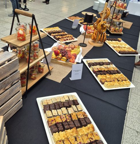 Buffet mit Kuchen, Obst, Brezeln und weiteren Snacks für die Teilnehmenden der Veranstaltung.