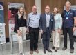 Fünf Personen stehen gemeinsam vor dem Informationsstand des Mittelstand-Digital Zentrums Ilmenau und weiteren Ausstellungsständen einer Fachveranstaltung.
