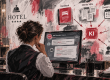 Hotelmitarbeiterin nutzt einen KI-Assistenten, der interne Informationen aus verschiedenen Datenquellen bündelt.