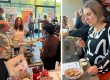 Teilnehmende tauschen sich an einem Messestand mit Mikroskop und Informationsmaterialien aus; daneben probiert jemand ein ausgestelltes Produkt