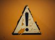 Warnschild an gelber Wand