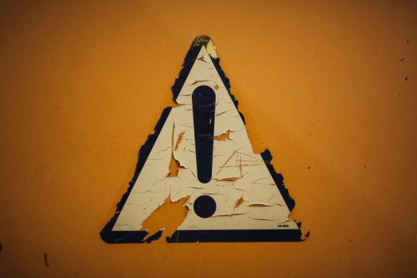 Warnung Warnschild an gelber Wand