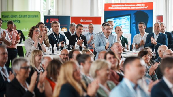 Menschen die stehen und sitzen und applaudieren